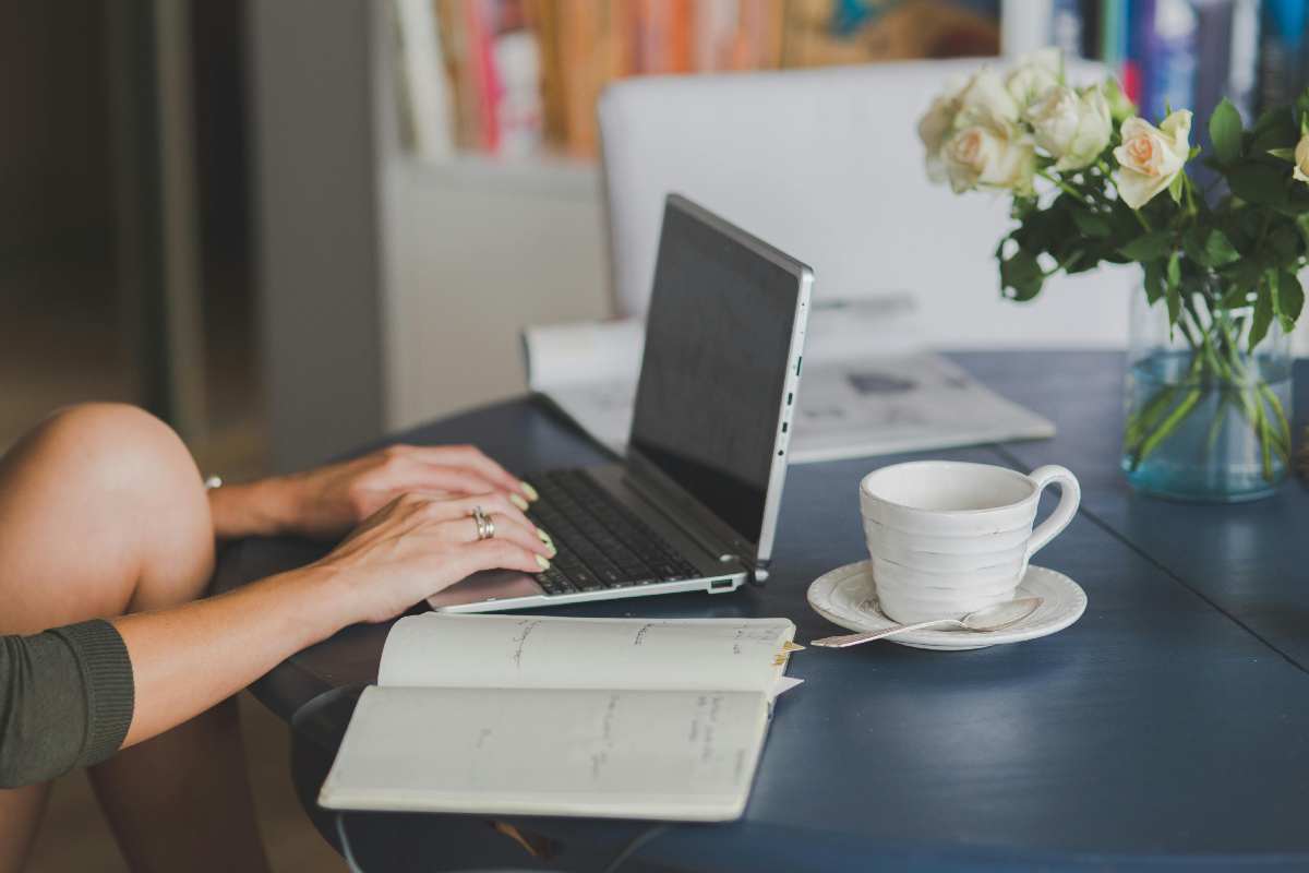 Una ragazza seduta alla scrivania che lavora al laptop