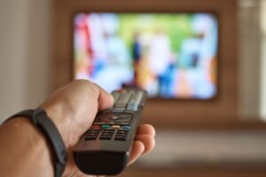 Uomo che punta telecomando verso la TV