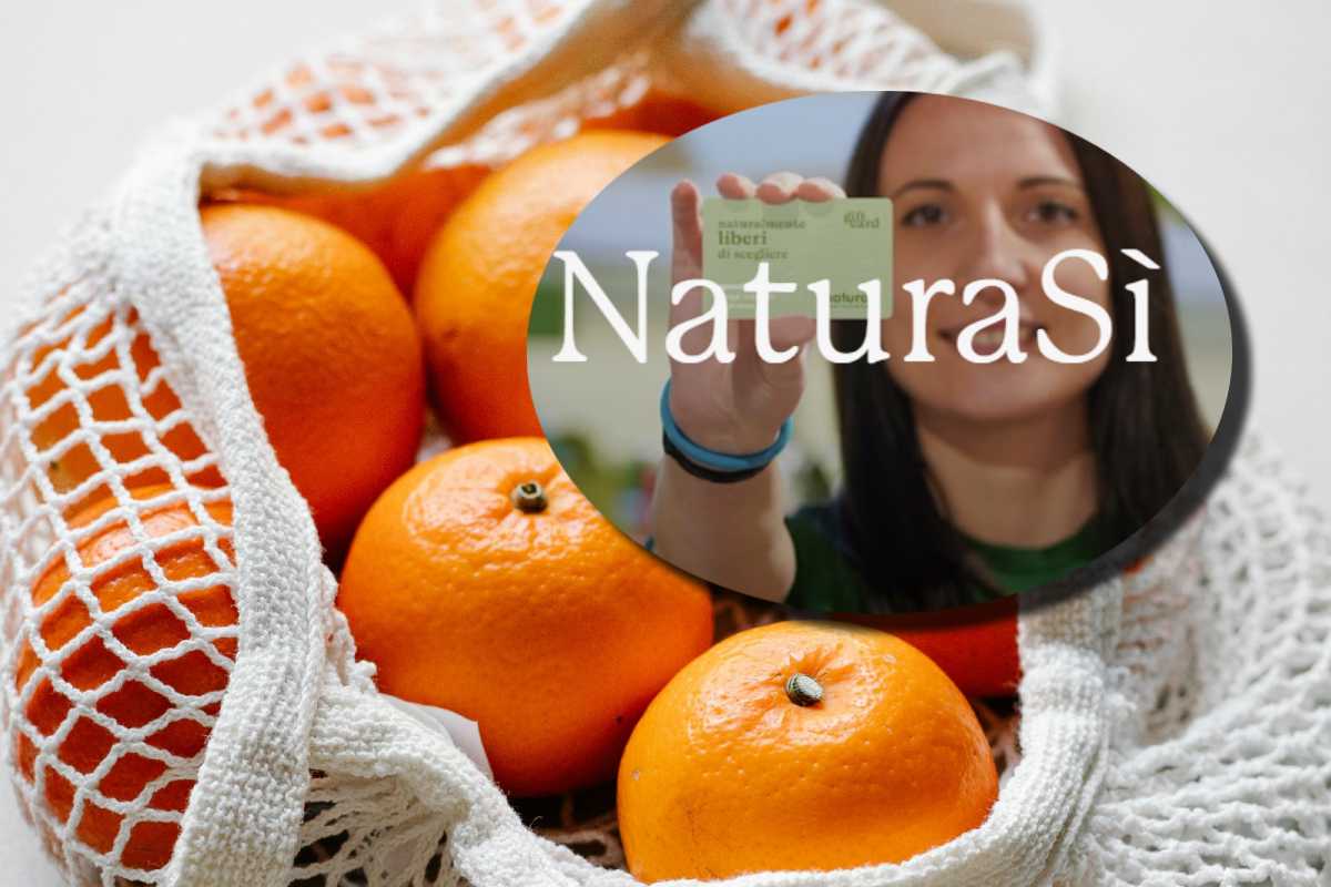 Delle arance in un sacco e, in evidenza, una donna con la tessera del supermercato bio NaturaSì