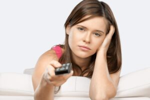 Donna triste con telecomando in mano