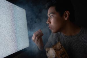 Un ragazzo davanti a una tv senza trasmissione