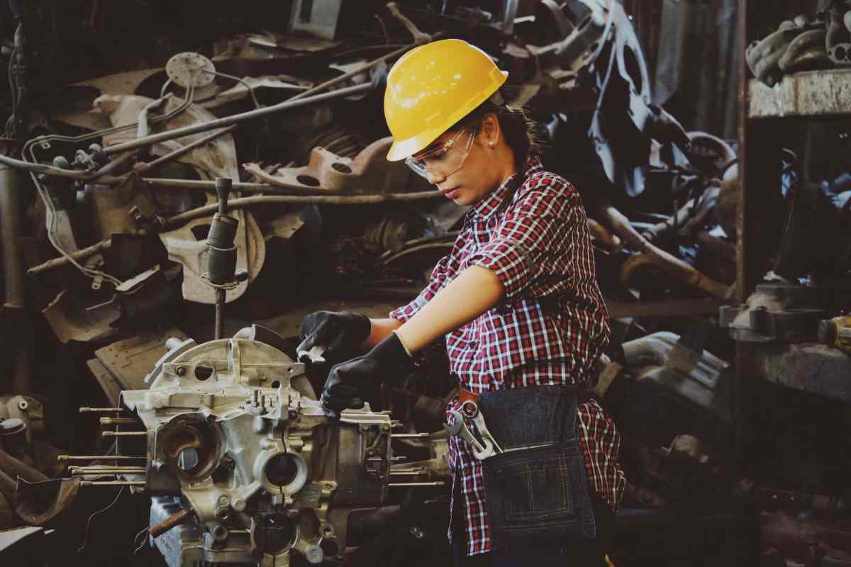 Un'operaia metalmeccanica con caschetto giallo