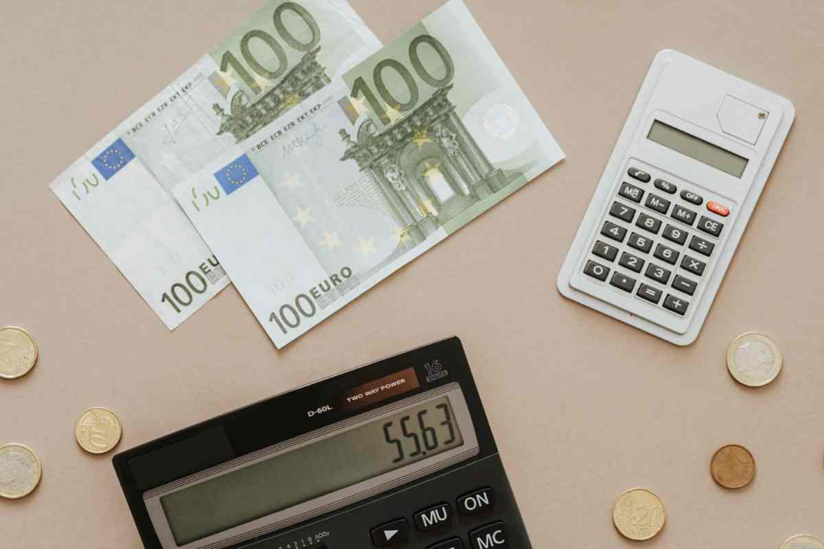 Due banconote da 100 euro e due calcolatrici su un tavolo