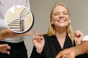 Una ragazza che sorride e indica una scala in un appartamento