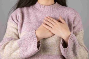 Donna con entrambe le mani sul cuore